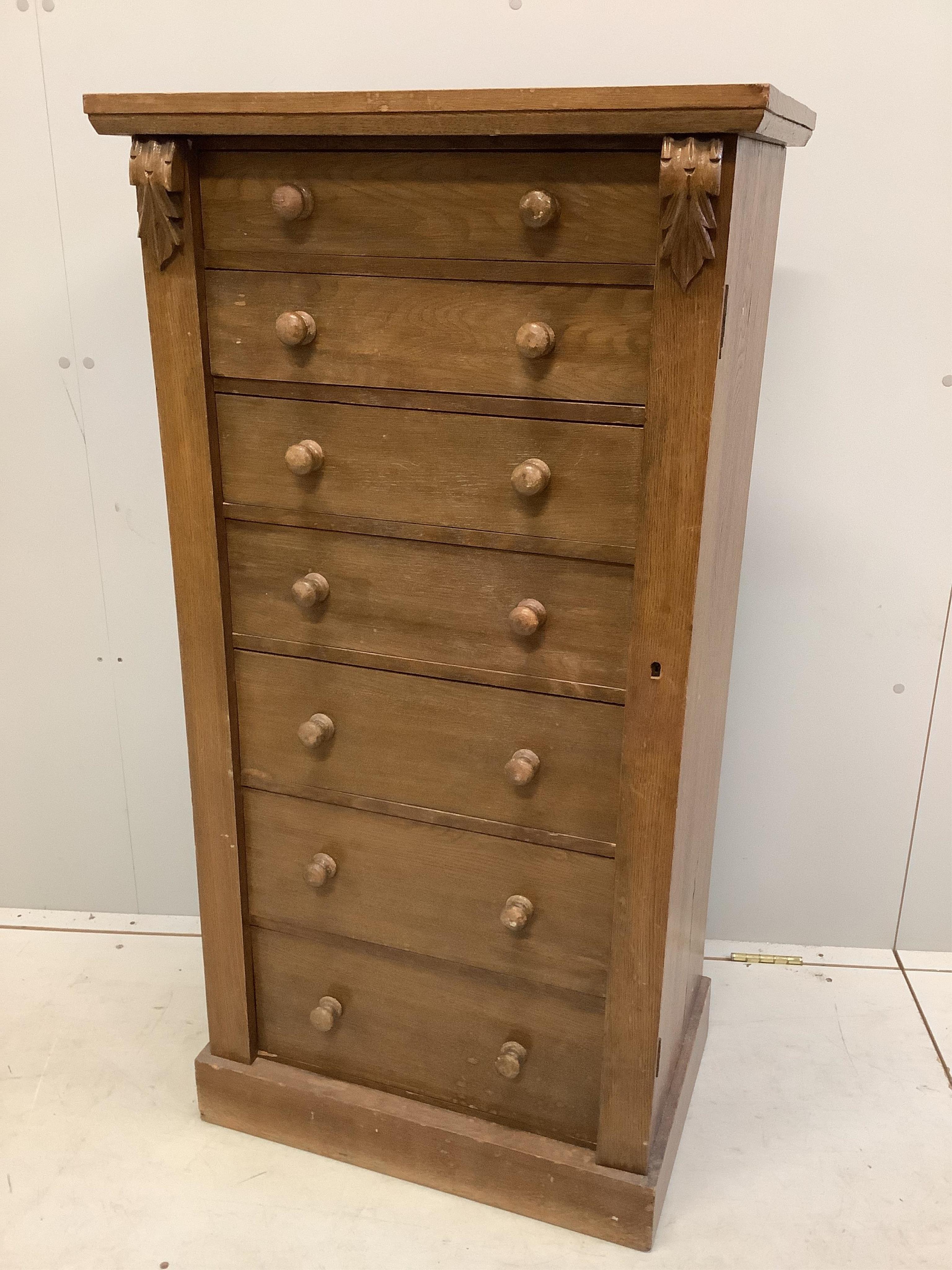 A Victorian style oak Wellington chest, width 60cm, depth 42cm, height 120cm. Condition - fair, top has a horizontal split, plinth foot scuffed and worn.